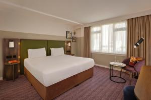 a hotel room with a large bed and a chair at Mount Royal Hotel Edinburgh by The Unlimited Collection in Edinburgh +27 photos