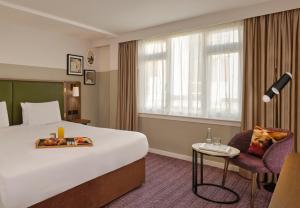 a hotel room with a bed and a chair at Mount Royal Hotel Edinburgh by The Unlimited Collection in Edinburgh
