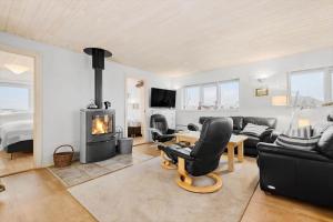 Una sala de estar con un sofá y una chimenea. en FAN001-Fano-Skraeddermarken-52, en Fanø