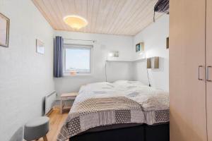 Un dormitorio pequeño con una cama y una ventana. en FAN001-Fano-Skraeddermarken-52, en Fanø