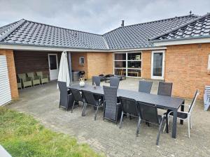 Un patio con una mesa y sillas y una sombrilla. en FAN001-Fano-Skraeddermarken-52, en Fanø
