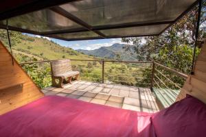 a room with a bed and a bench on a balcony at Mamaterra Glamping in Macanal