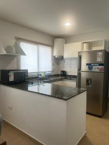 a kitchen with a counter top and a refrigerator at Departamento Soles in Posadas