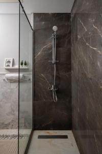 a shower with a glass door in a bathroom at AEON Towers Lucky Cloud #701 in Banī Ghālib