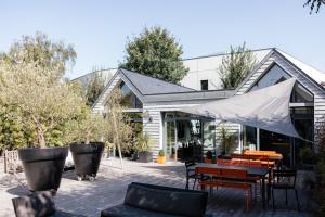 Maison contemporaine Centre DEAUVILLE - " 3 NUITS MINIMUM" في دوفيل: فناء مع طاولة وكراسي ومبنى