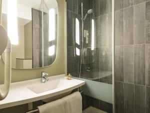 a bathroom with a sink and a shower at ibis Paris Gare du Nord Château Landon 10ème in Paris +32 photos