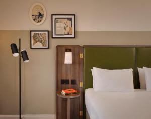 a bedroom with a bed with a green headboard at Mount Royal Hotel Edinburgh by The Unlimited Collection in Edinburgh