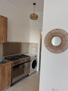 a kitchen with a stove and a washing machine at Velipoja Dream Villa in Velipojë