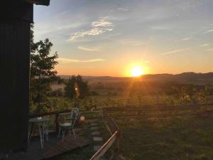a sunset on a patio with a table and chairs at Tiny house nad vinicí in Jičín