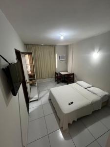 pokój hotelowy z łóżkiem i telewizorem w obiekcie Residencial Sol - Cidade alta w mieście Natal