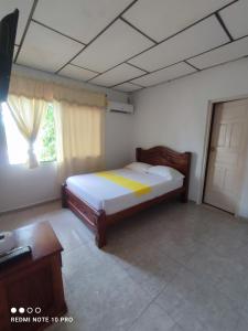 a small bedroom with a bed and a window at HOSPEDAJE CASA JENIFER SPA MOMPOXx in Mompós