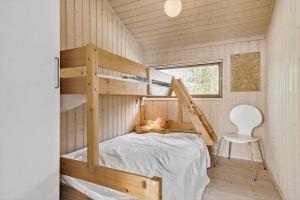 ein kleines Haus mit einem Etagenbett und einem Stuhl in der Unterkunft 8451 Knebel - Fyrrevej 9 in Knebel