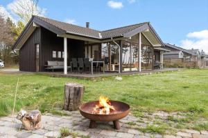 eine Feuerstelle vor einem Haus in der Unterkunft 8451 Knebel - Fyrrevej 9 in Knebel