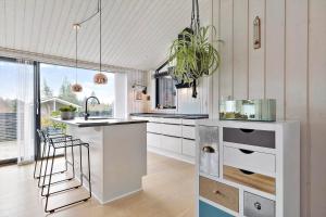 a kitchen with white cabinets and a potted plant at 8411-Ebeltoft-Fyrbakken-13 in Ebeltoft