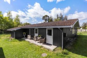 a black shed with a porch in a field at 8003-Knebel-Skodshovedgard-41 in Knebel