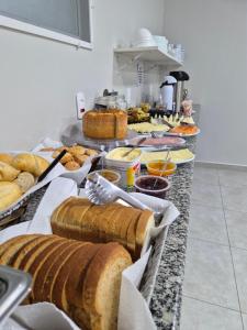 a buffet with bread and other foods on a counter at Hotel Dona Pina in Francisco Beltrão