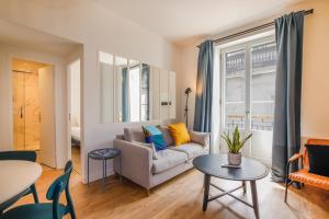 una sala de estar con un sofá y una mesa en Appartements - Bordeaux Centre Gare, en Burdeos