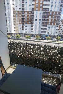 a table on a balcony with a view of buildings at Apartman Urban Rest in Doboj