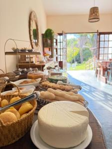 a table topped with lots of different types of bread at Pousada Casa Cerrado in Colinas Do Sul