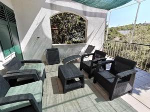 een terras met stoelen en een tafel en een tafel en stoelen bij Apartments DeMori in Primošten