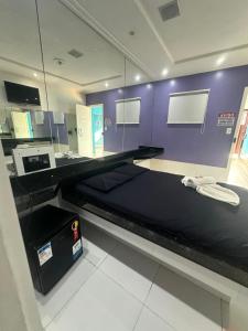 a bed in a room with a purple wall at Pousada La Ñina in Belém