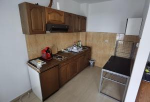 a kitchen with wooden cabinets and a sink and a refrigerator at Apartman Urban Rest in Doboj