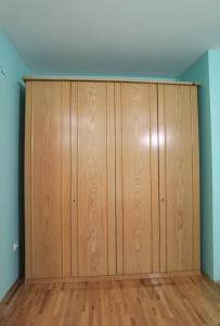 a large wooden closet in a room with wooden floors at Apartman Urban Rest in Doboj