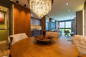 ein Esszimmer mit einem Tisch und einem Kronleuchter in der Unterkunft Rosa Edificio Residencial Storia in Gramado