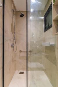 eine Dusche mit Glastür im Badezimmer in der Unterkunft Rosa Edificio Residencial Storia in Gramado + 17 Fotos