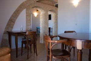 a dining room with tables and chairs and an archway at Residenza delle Grazie in Miglionico