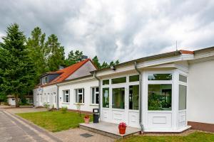 a white house with a lot of windows at Jugendbegegnungsstätte Am Kutzow-See Plöwen in Plöwen