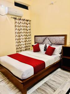 a bedroom with a large bed with red pillows at Hotel Heritage in Varanasi +78 photos