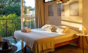a bedroom with a bed with towels on it at Pousada Contêiner 10 in Serra