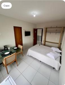 een slaapkamer met een bed, een tafel en een bureau bij Residencial Sol - Cidade alta in Natal