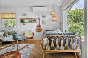 a bedroom with a bed and a table and a guitar at 30116-Odder-P-Baatrupsvej-47 in Beder