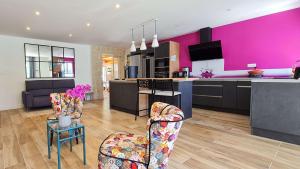 cocina y sala de estar con paredes de color rosa en Superbe villa avec piscine chauffée, boulodrome et parking, en Sainte-Marie-de-Ré