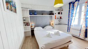 Un dormitorio con una cama con dos toallas encima. en Superbe villa avec piscine chauffée, boulodrome et parking, en Sainte-Marie-de-Ré 6 fotos más