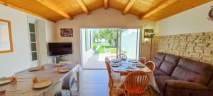 una sala de estar con una mesa y un sofá en Superbe villa avec piscine chauffée, boulodrome et parking, en Sainte-Marie-de-Ré