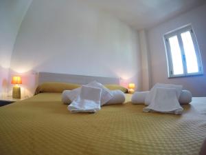 a bedroom with a large bed with towels on it at Residence Pantaleo in Ricadi
