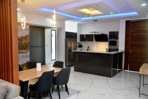 a kitchen and dining room with a wooden table and chairs at PalmView - Saly Ngaparou in Saly Portudal