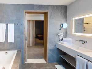 a bathroom with a tub and a sink and a mirror at NOVOTEL KOLWEZI in Kolwezi +13 photos