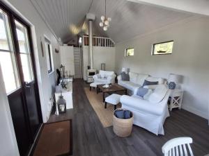 un soggiorno con divani bianchi e tavolo di Beachfront holiday home with sea view in Sölvesborg a Torsö
