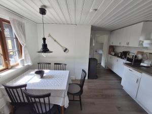 una cucina e una sala da pranzo con tavolo e sedie di Beachfront holiday home with sea view in Sölvesborg a Torsö