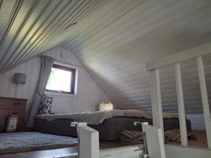 una camera con un letto e una finestra in mansarda di Beachfront holiday home with sea view in Sölvesborg a Torsö