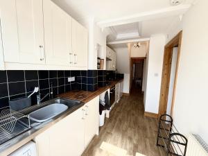 a kitchen with white cabinets and a sink at Roof Garden @ No.60 High Street in Lyndhurst +19 photos