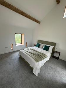 a bedroom with a large bed in a room with a window at Threshing Barn- Modern 5 Bed, 10 person, Barn Conversion in a Rural Location with Great Access in Silkstone