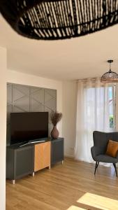 ein Wohnzimmer mit Fernseher und Sessel in der Unterkunft AMAO Grey - 86 m2 Apartment - Balcony - King-Size Beds - Free Parking - Near Europa-Park - Up to 12 Guests with 2 Units in Rheinhausen