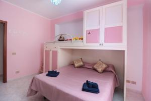 a pink bedroom with a bed and a white cabinet at Appartamento Le Palme Tra Taormina e Catania in Linera +83 photos