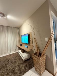a living room with a television on a wall at Iloa resort AP luxo in Barra de São Miguel +34 photos
