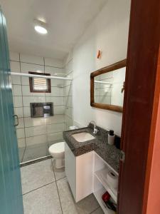 ein Badezimmer mit Waschbecken, Toilette und Spiegel in der Unterkunft Casa Sofia - Macapá Paradise in Luis Correia
